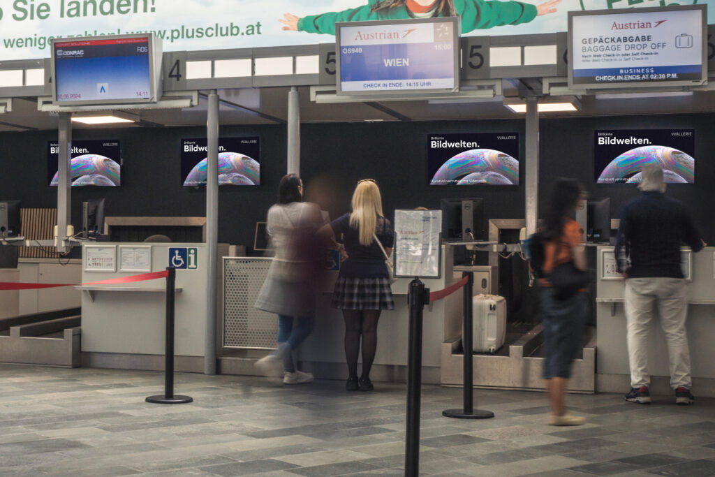 Digital Signage Indoor Screens hinter Check In im Flughafen Klagenfurt