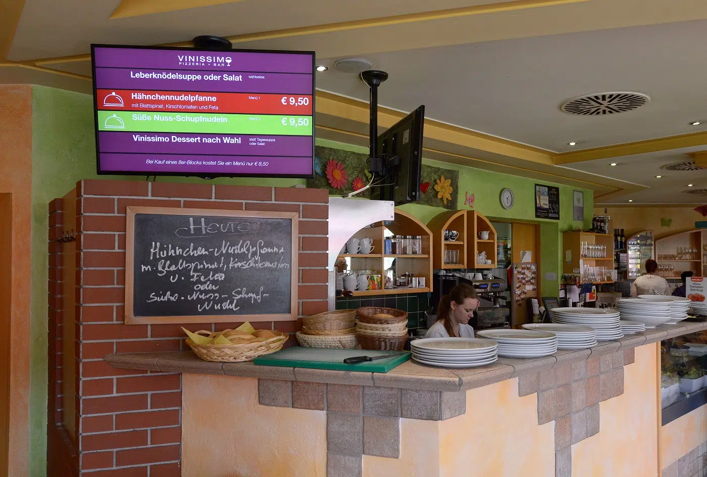 Digital Signage Indoor Screen hängend über dem Tresen mit einem Menüplan
