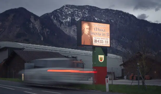 Eine Nachtaufnahme eine LED Wall neben der Strasse und verschwommen ein Auto das vorbeifährt