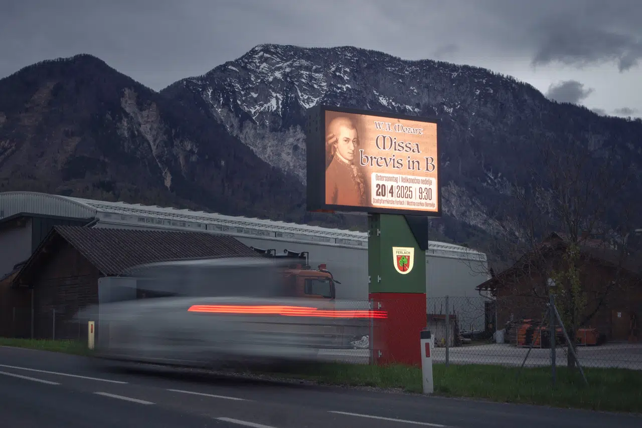 Eine Nachtaufnahme eine LED Wall neben der Strasse und verschwommen ein Auto das vorbeifährt