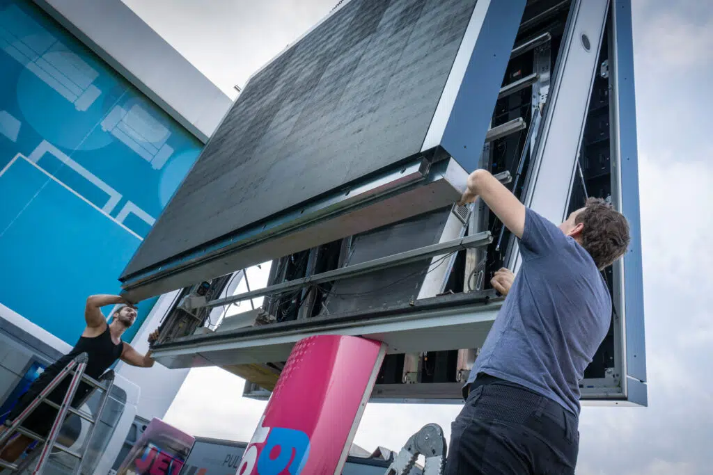 modernisierung-dooh-werbenetzwerk-monitorwerbung 2 Mitarbeiter tauschen die LED Wall aus