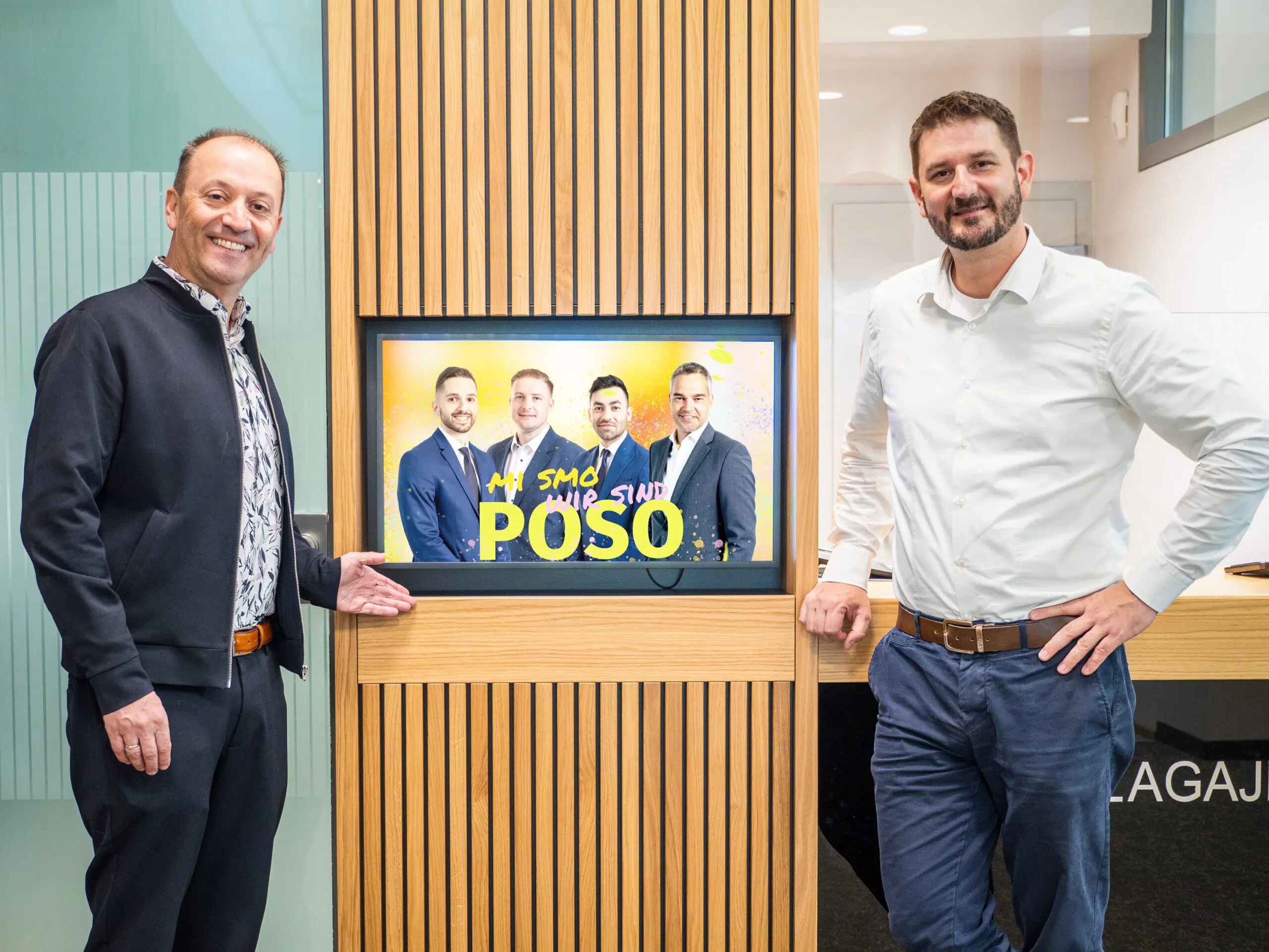 poso-bank-managed-digital-signage-system-by-wallerie Andreas Lanner von LANNER Media und Daniel Riegelnik von der Poso Bank neben einem Indoor Screen